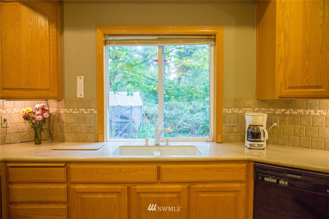 22705 Peter Grubb Road Southeast Renton, WA 98058 - Photo 7 of 40 a bathroom with a granite countertop sink and a large mirror next to a window