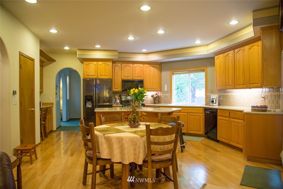 22705 Peter Grubb Road Southeast Renton, WA 98058 - Photo 8 of 40 a dining hall with stainless steel appliances a dining table and chairs