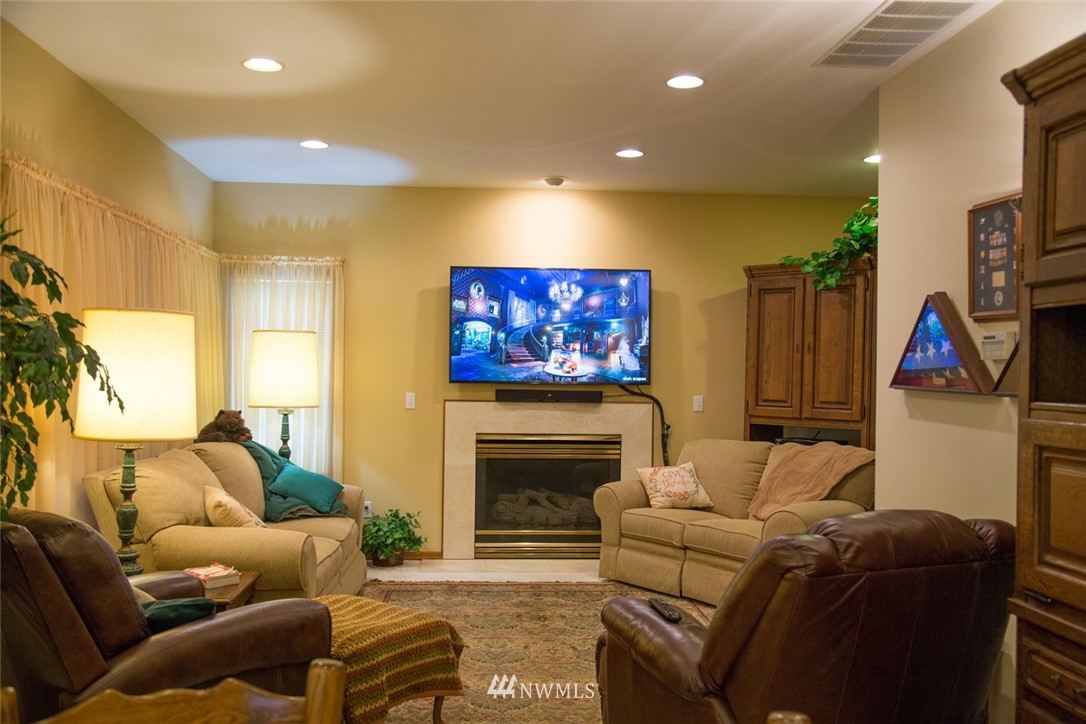 22705 Peter Grubb Road Southeast Renton, WA 98058 - Photo 9 of 40 a living room with furniture a flat screen tv and a fireplace