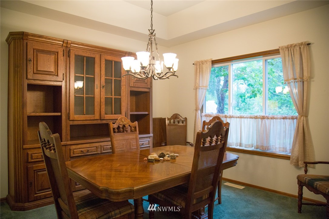 22705 Peter Grubb Road Southeast Renton, WA 98058 - Photo 10 of 40 a dining room with furniture a chandelier and window