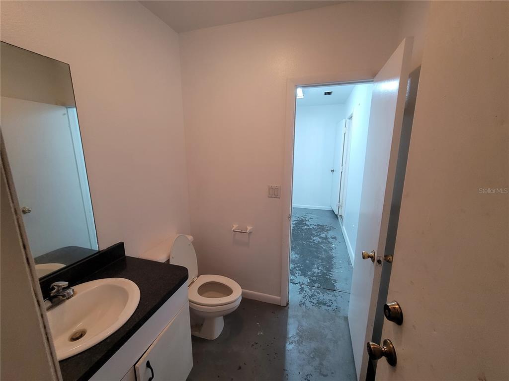 37515 Phelps Road Zephyrhills, FL 33541 - Photo 12 of 25 a bathroom with a granite countertop toilet a sink and a mirror