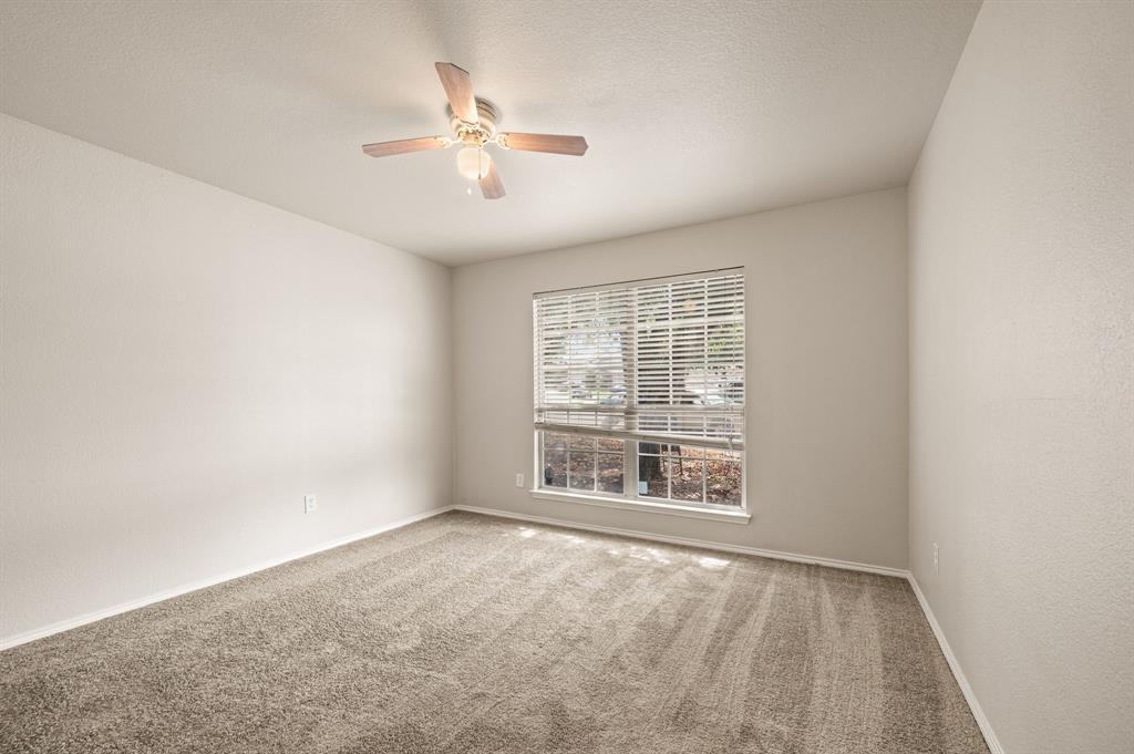 5509 Timber Ridge Court Watauga, TX 76137 - Photo 8 of 28 Neutral wall tones, ceiling fan with light fixture, window with horizontal blinds, and carpeting