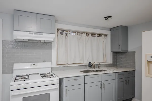 a kitchen with granite countertop a sink stove and cabinets