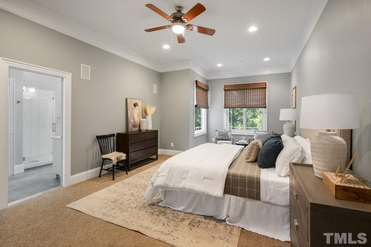 5909 Greenevers Drive Raleigh, NC 27613 - Photo 13 of 30 a bedroom with a bed and a chandelier
