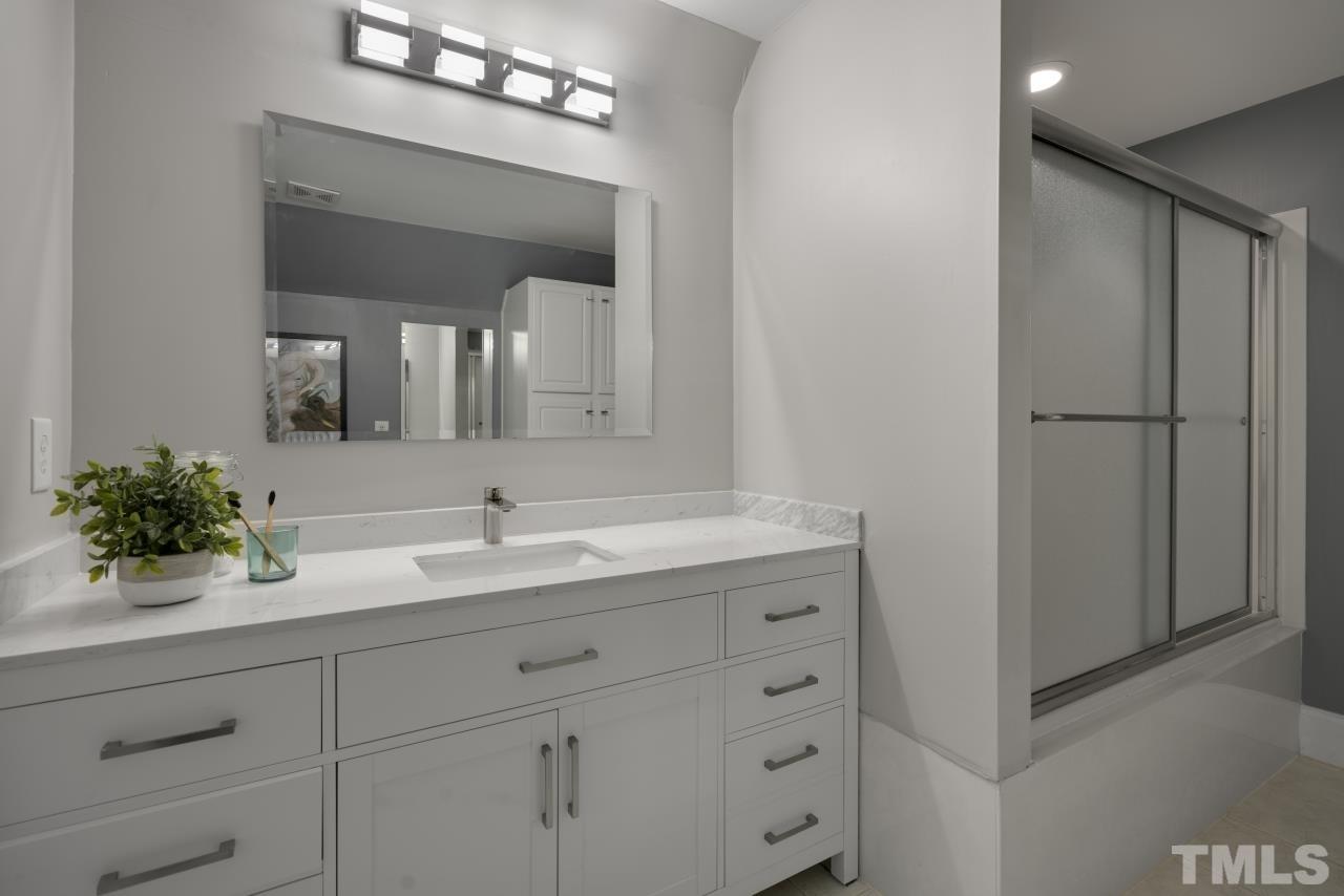 5909 Greenevers Drive Raleigh, NC 27613 - Photo 20 of 30 a bathroom with a double vanity sink and a mirror