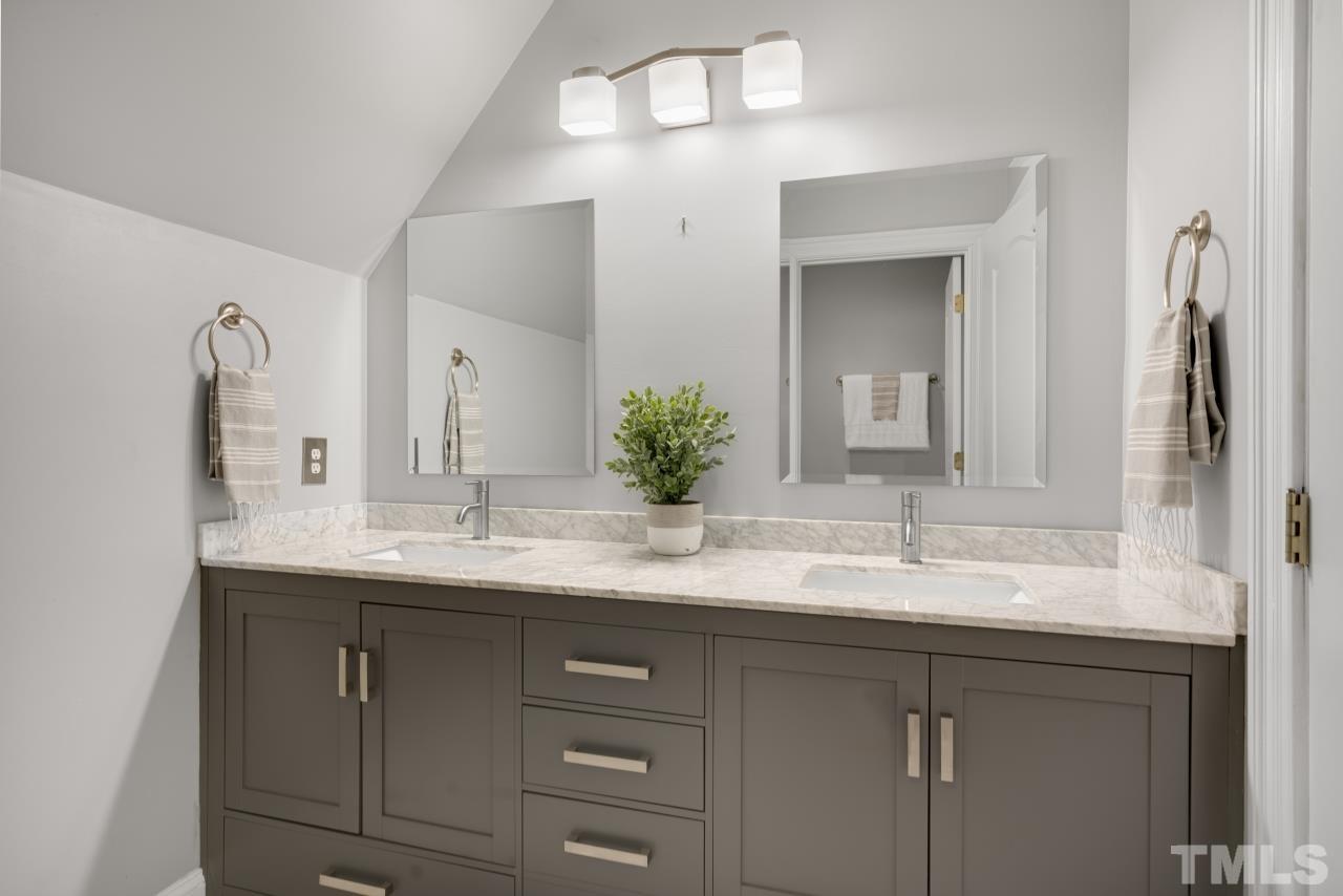 5909 Greenevers Drive Raleigh, NC 27613 - Photo 23 of 30 a bathroom with a double vanity sink and a mirror