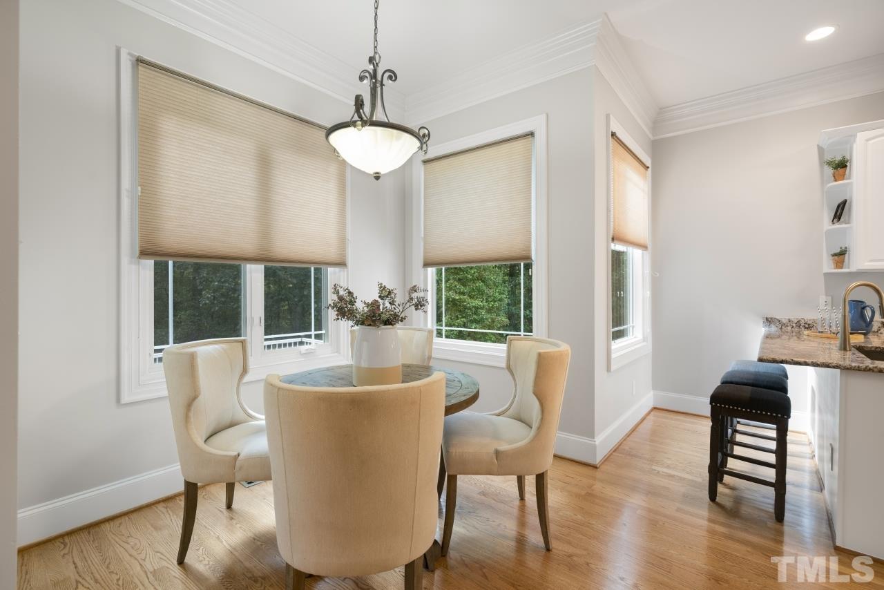 5909 Greenevers Drive Raleigh, NC 27613 - Photo 8 of 30 a dining room with furniture a chandelier and wooden floor