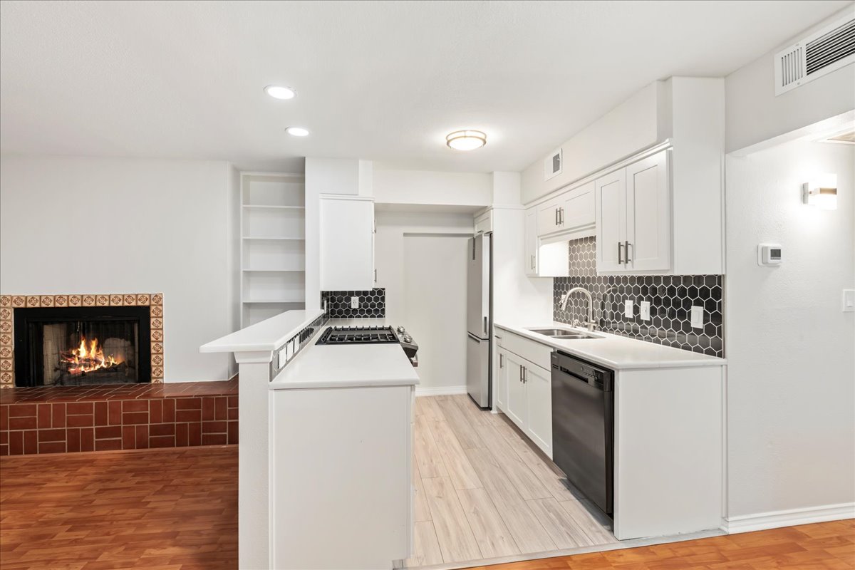 505 West 7th Street, Unit 313 Austin, TX 78701 - Photo 6 of 30 Kitchen featuring a peninsula, a sink, light wood-type flooring, freestanding refrigerator, and dishwasher