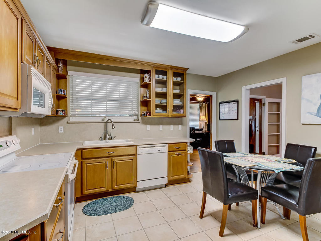 1526 Somerville Road Jacksonville, FL 32207 - Photo 13 of 30 a kitchen with a dining table chairs and a refrigerator