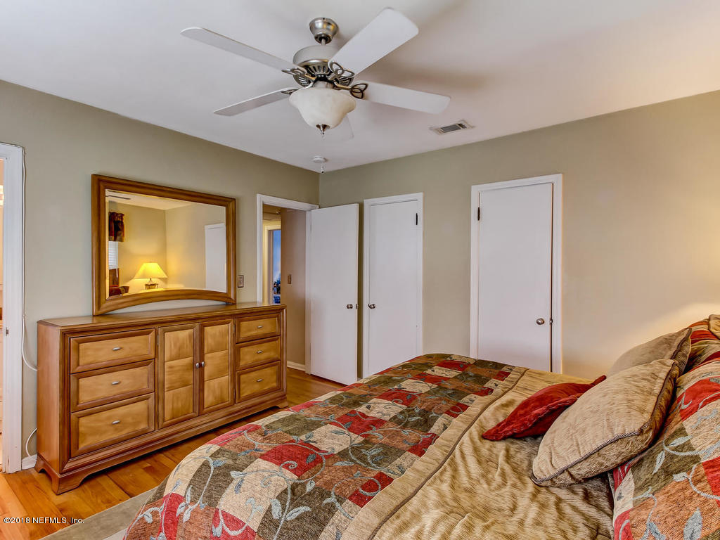 1526 Somerville Road Jacksonville, FL 32207 - Photo 21 of 30 a bedroom with a bed a chandelier and dresser