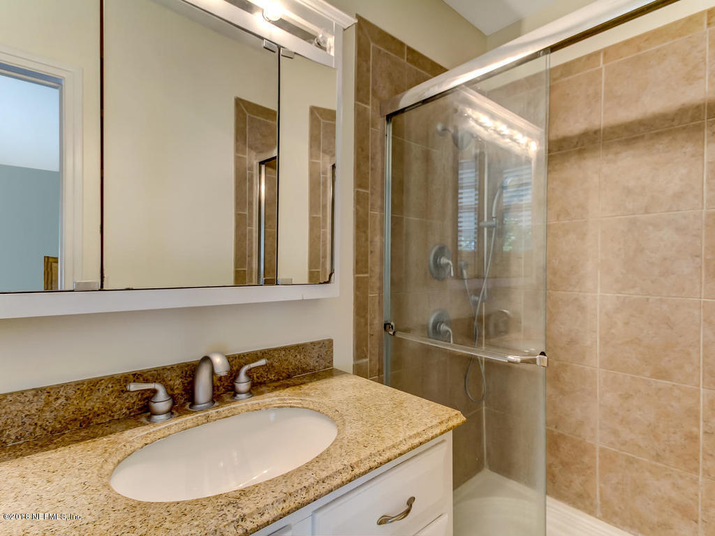 1526 Somerville Road Jacksonville, FL 32207 - Photo 23 of 30 a bathroom with a granite countertop sink mirror and a shower