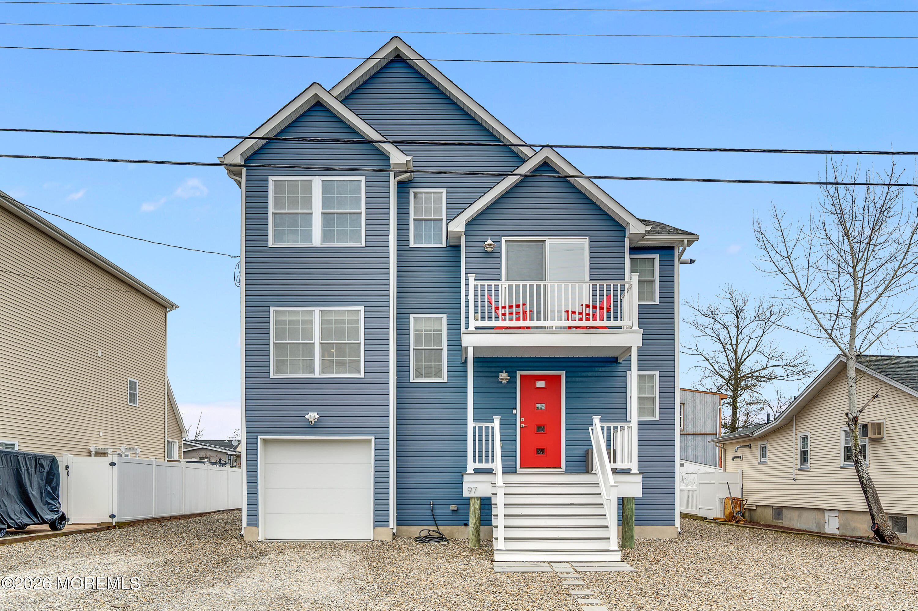 a view of a white house with large windows and a road