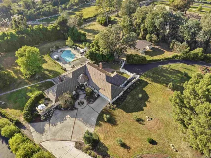 an aerial view of a house with a yard and lake view
