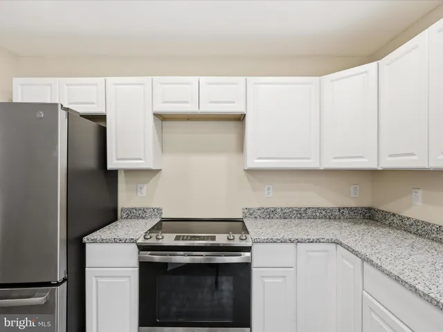 an empty room with wooden floor ceiling fan and windows