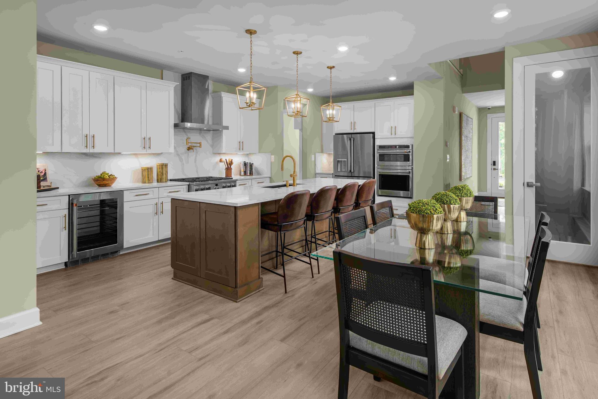 5446 Pondview Lane Ellicott City, MD 21043 - Photo 3 of 21 a kitchen with stainless steel appliances kitchen island granite countertop a table chairs sink and cabinets