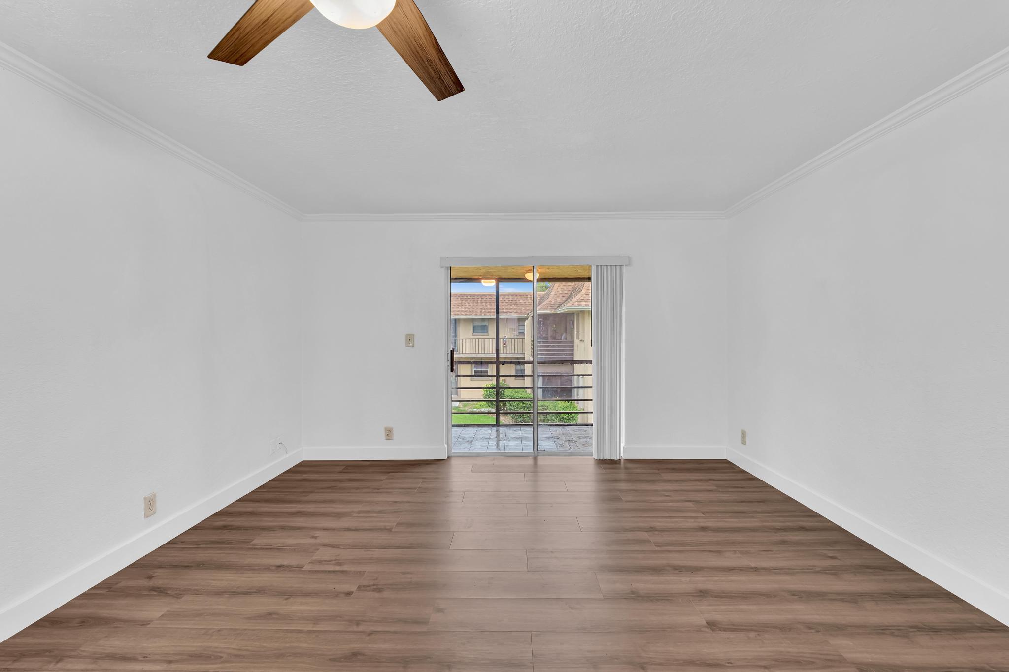 1291 Northwest 13th Street, Unit 445D Boca Raton, FL 33486 - Photo 8 of 50 an empty room with wooden floor and windows
