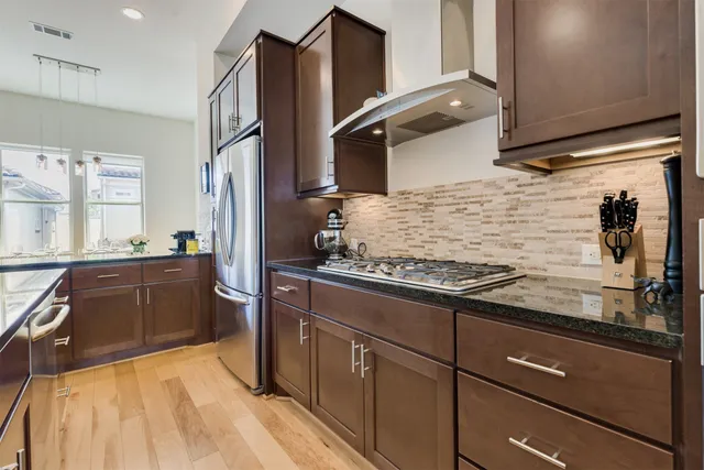 a kitchen with stainless steel appliances granite countertop a refrigerator and a stove