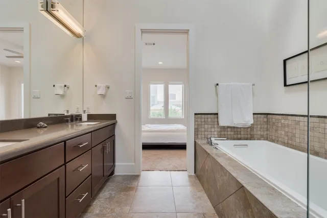a spacious bathroom with a tub sink and mirror