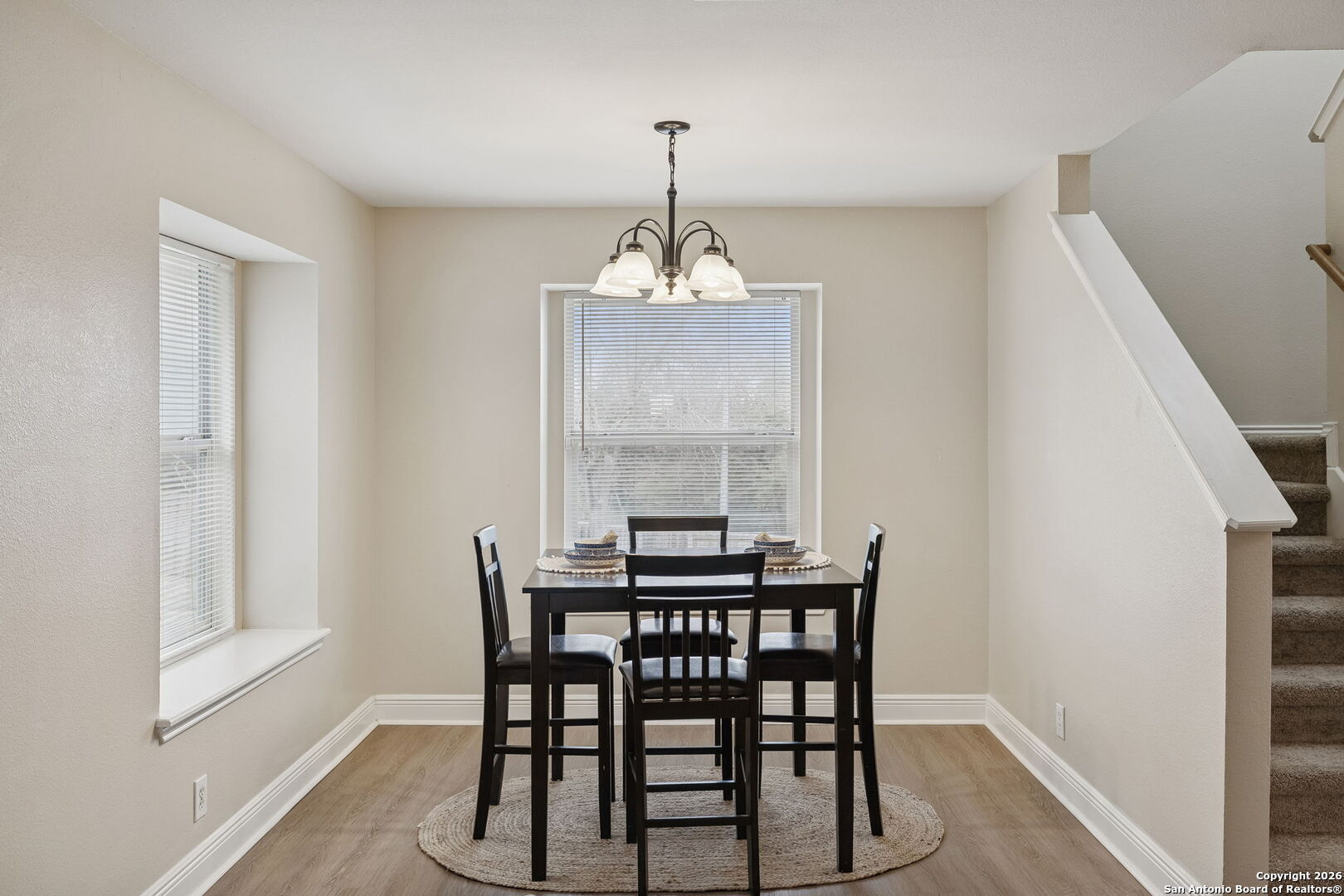 10310 Springwood Square Universal City, TX 78148 - Photo 11 of 44 a dining room with wooden floor a chandelier a wooden table and chairs