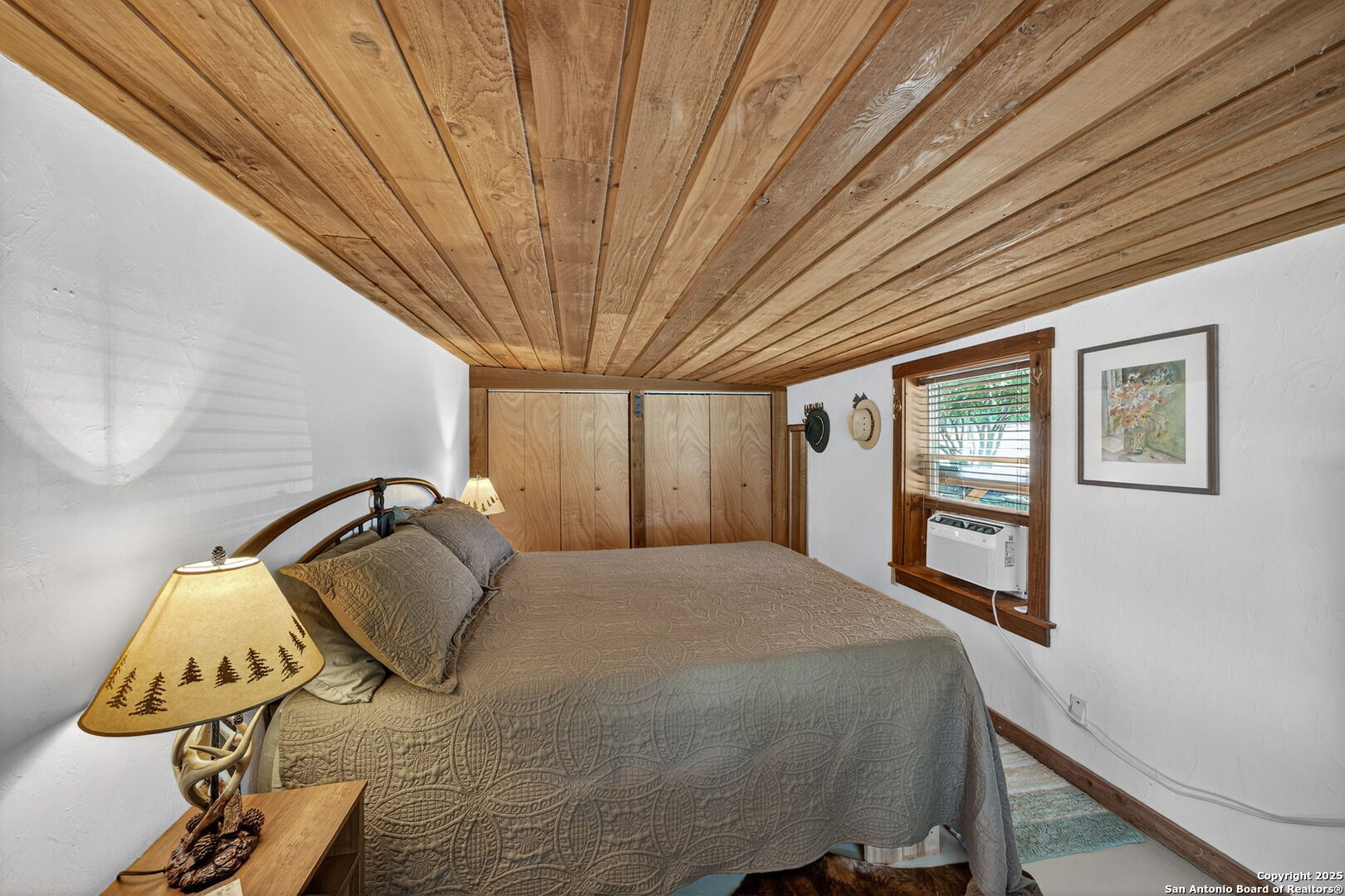 924 Wagon Creek Road Bandera, TX 78003 - Photo 13 of 33 a bedroom with a bed and wooden floor