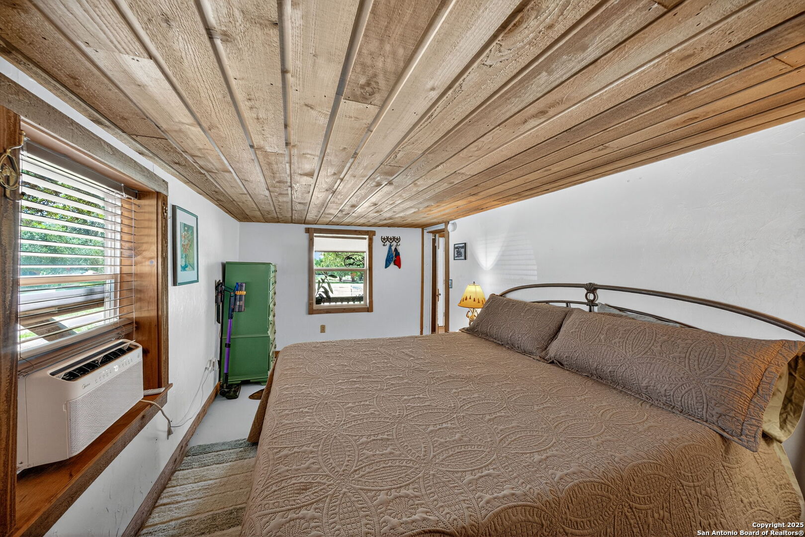 924 Wagon Creek Road Bandera, TX 78003 - Photo 14 of 33 a bedroom with a large bed and a chandelier