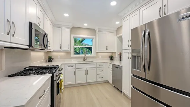 a kitchen with granite countertop white cabinets and a window