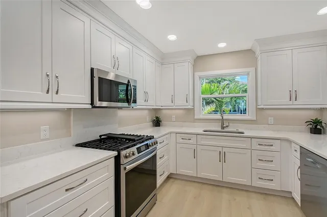 a kitchen with stainless steel appliances a refrigerator sink and stove