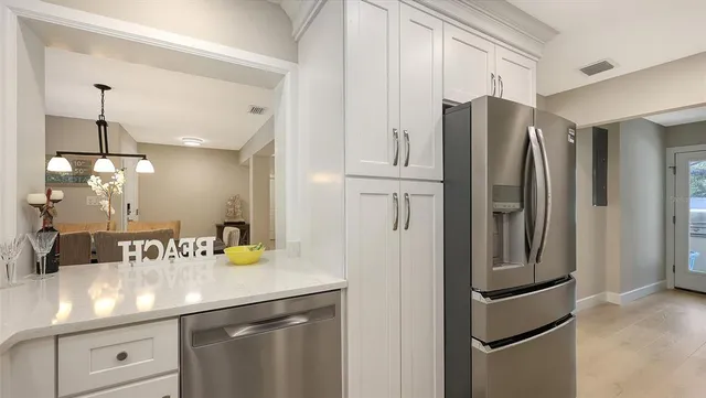 a white bed sitting in a room next to a window