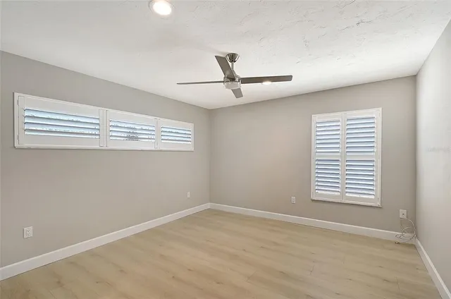 a view of a patio with couches table and chairs under an umbrella