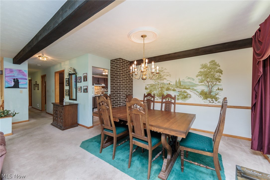 2170 Norton Road Stow, OH 44224 - Photo 28 of 48 Dining area featuring a decorative ceiling medallion with a chandelier, exposed wood beams, and a painted landscape mural