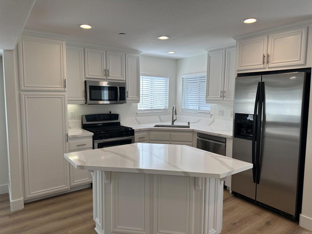 4026 Aidan Circle Carlsbad, CA 92008 - Photo 2 of 26 a kitchen with kitchen island a center island stainless steel appliances and cabinets