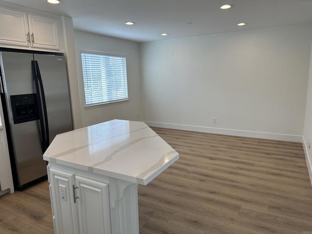 4026 Aidan Circle Carlsbad, CA 92008 - Photo 4 of 26 a view of kitchen island a sink wooden floor and entryway