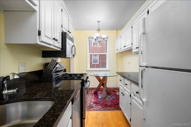a kitchen with stainless steel appliances granite countertop a sink stove and cabinets