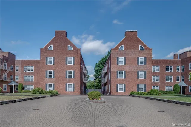front view of a brick house with a yard