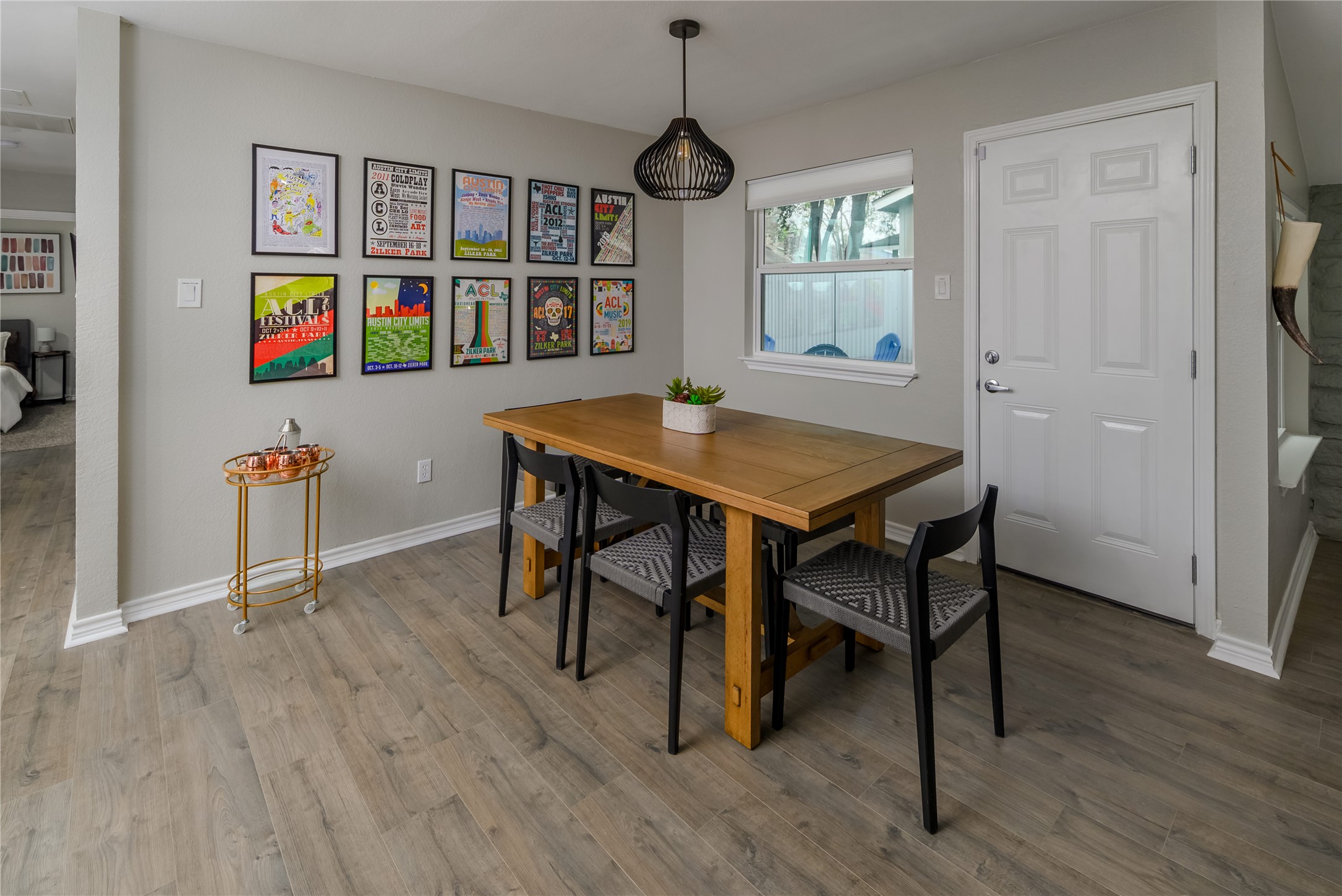 1651 Chippeway Lane Austin, TX 78745 - Photo 11 of 26 a dining room with wooden floor a chandelier a wooden table and chairs