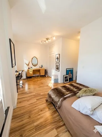 a bedroom with a bed and wooden floor