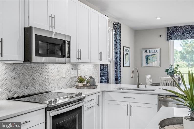 3452 Jacobs Ford Way Hanover, MD 21076 - Photo 8 of 28 a kitchen with stainless steel appliances white cabinets and a stove top oven