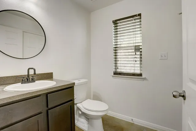 a bathroom with a toilet a sink and a mirror