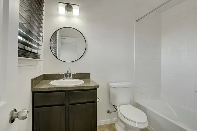 a bathroom with a toilet a sink and mirror