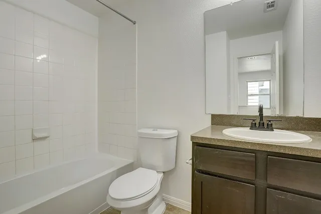 a bathroom with a granite countertop sink toilet a mirror and shower