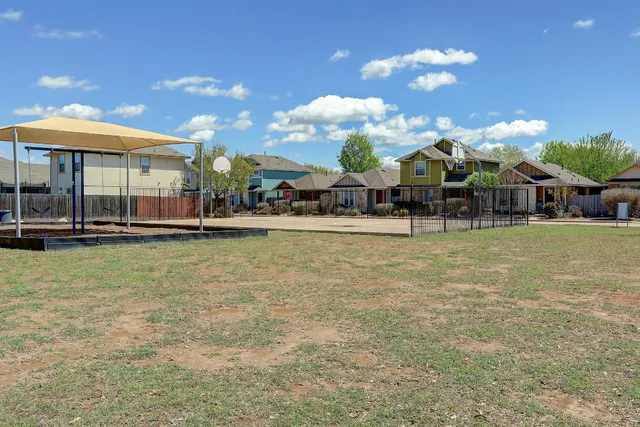 a backyard of a house with table and chairs