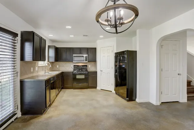 a kitchen with stainless steel appliances granite countertop a refrigerator a stove top oven a sink and dishwasher