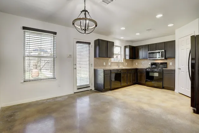 a large kitchen with stainless steel appliances granite countertop a stove and a sink