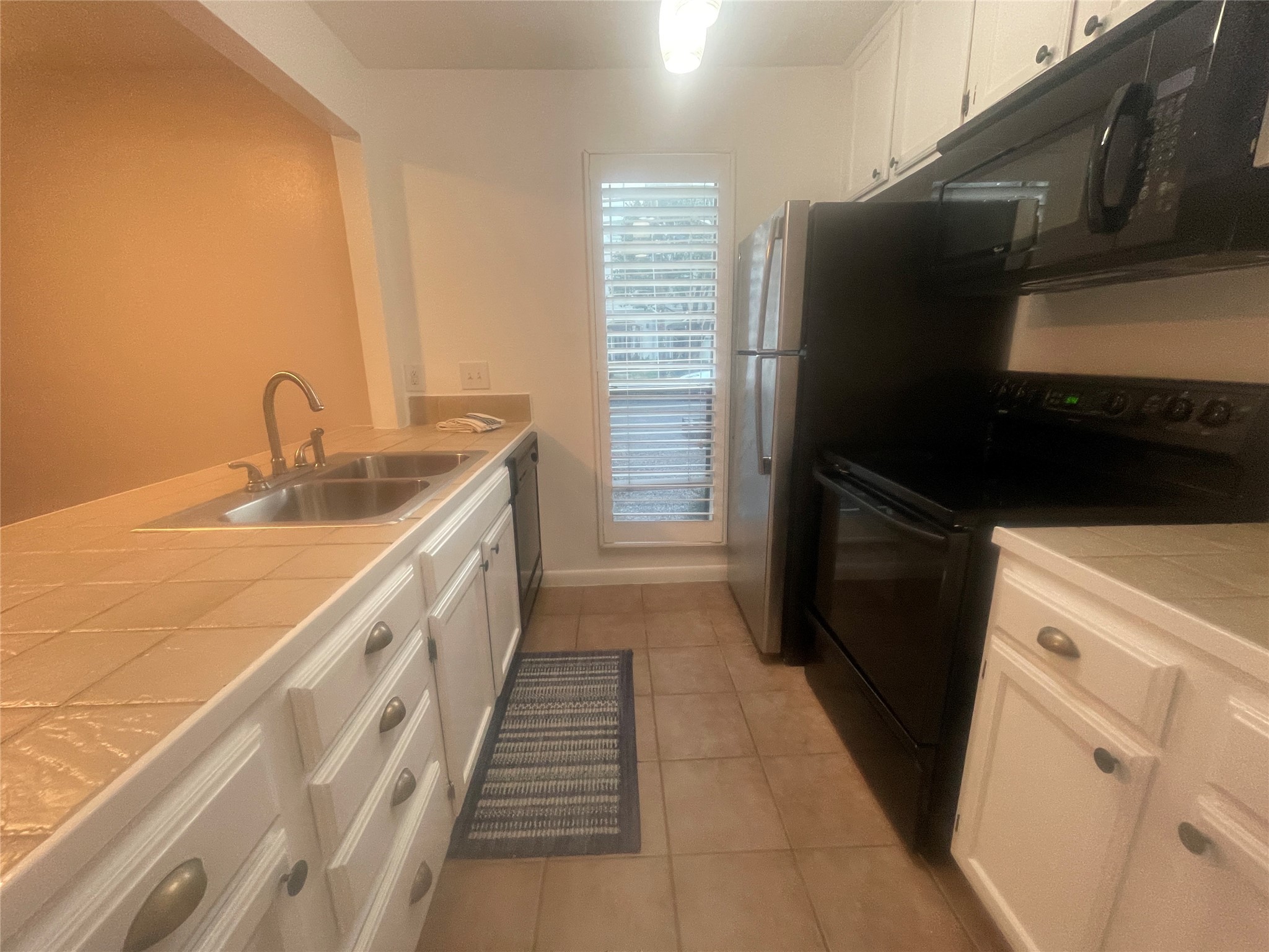 a kitchen with granite countertop a refrigerator and a sink