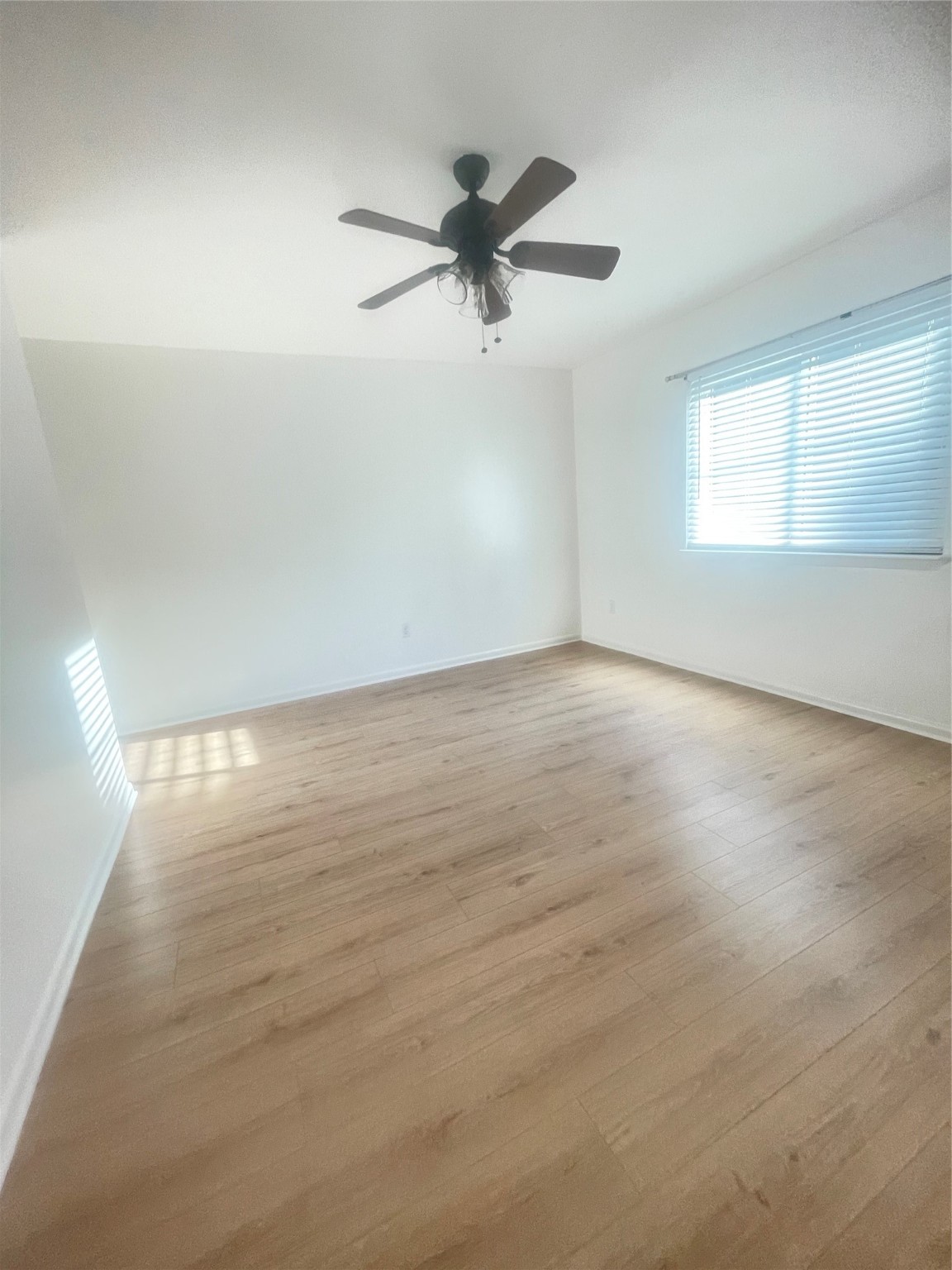 701 Rosedale Street, Unit H Houston, TX 77006 - Photo 11 of 20 an empty room with wooden floor fan and windows