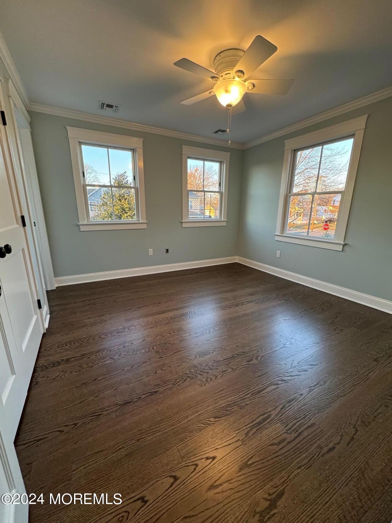 67 Sunset Avenue Red Bank, NJ 07701 - Photo 2 of 39 an empty room with wooden floor chandelier fan and windows