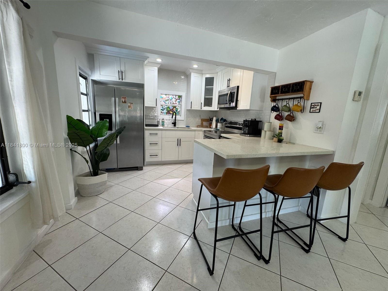 3901 Southwest 6th Street, Unit 1 Miami, FL 33134 - Photo 6 of 6 a kitchen with stainless steel appliances kitchen island granite countertop a sink and cabinets