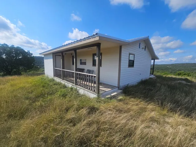 a view of a dry yard with wooden fence