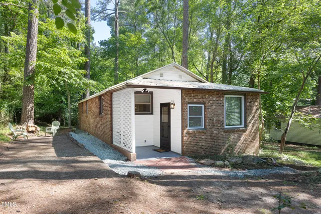 a front view of a house with a yard and trees