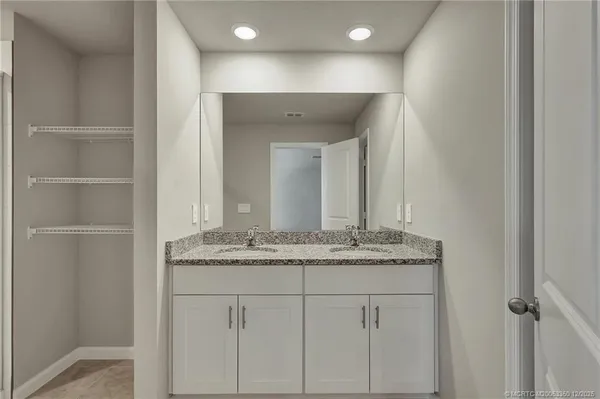 a bathroom with a granite countertop sink and a mirror